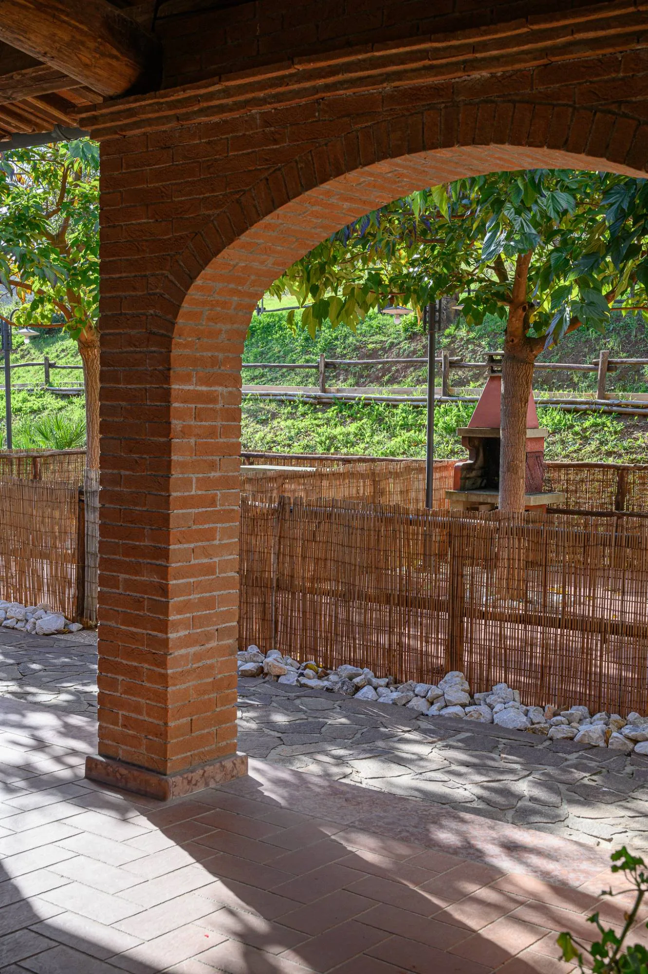 An apartment's portico and its fenced outdoor space, with the barbecue