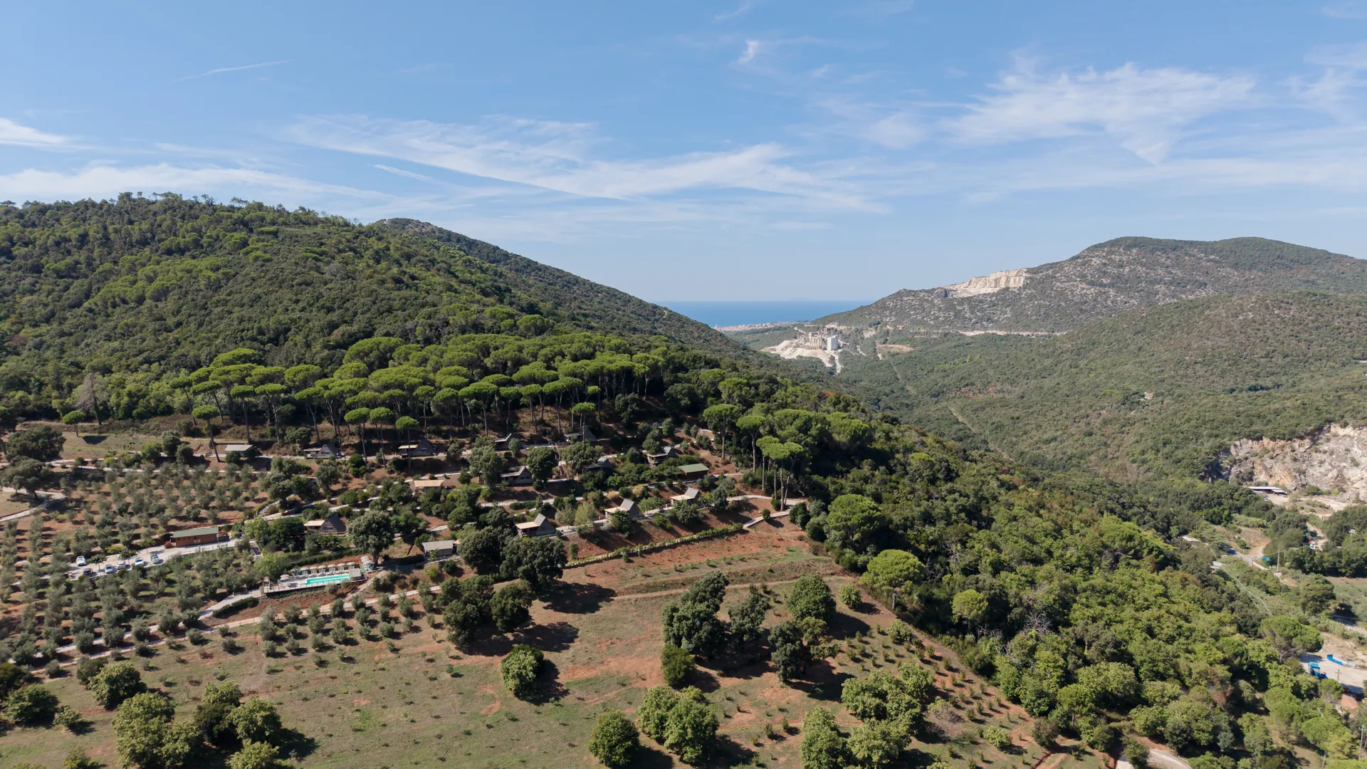 The glamping on the hillside with the sea in the distance