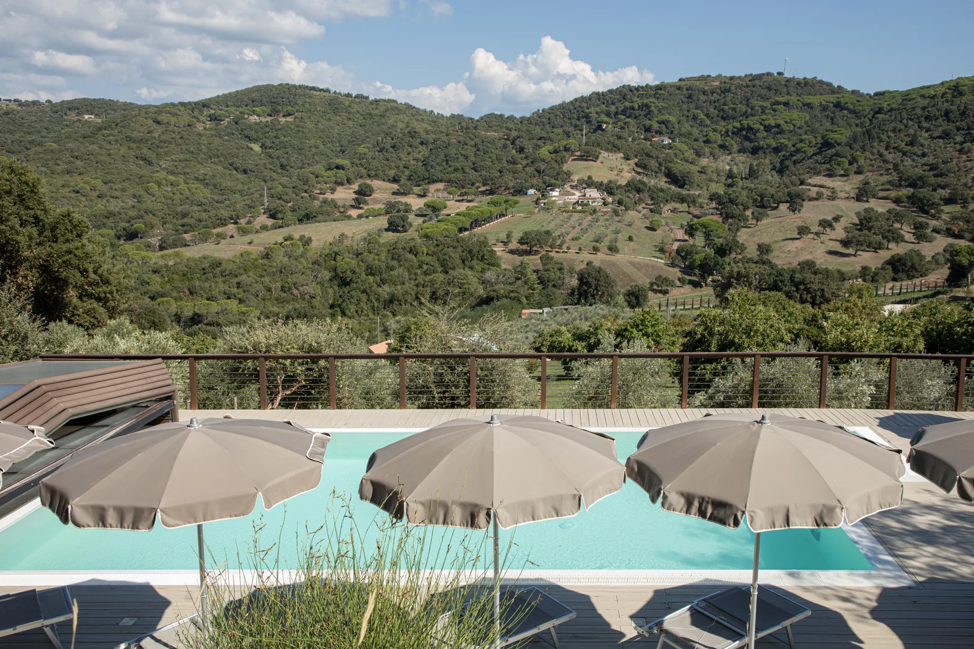 Parasols by the panoramic pool, overlooking the hills